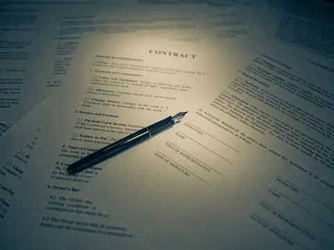Contrat imprimé et stylo plume posés sur un bureau