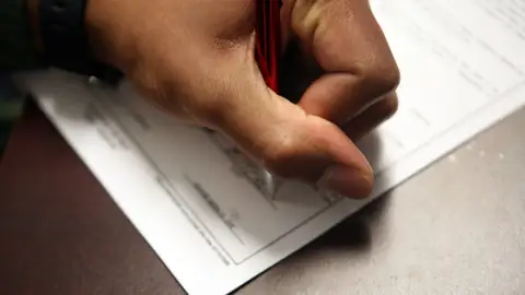 Main qui signe un document