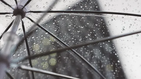 Parapluie transparent couvert de gouttes de pluie, vu de dessous