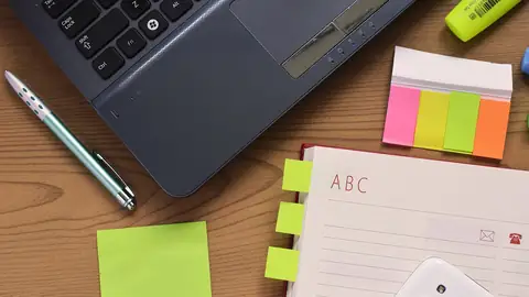 Bureau avec ordinateur portable, bloc-notes et stylo