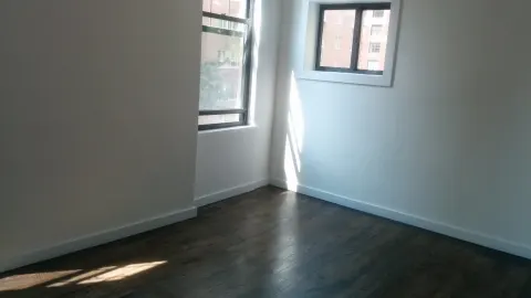 Chambre vide d’un appartement, murs blancs, plinthes et parquet, telle qu’on la décrit lors d’un état des lieux