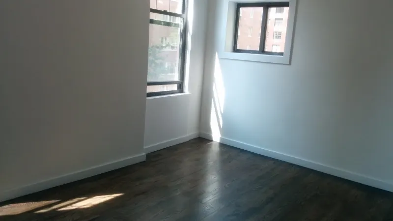 Chambre vide d’un appartement, murs blancs, plinthes et parquet, telle qu’on la décrit lors d’un état des lieux
