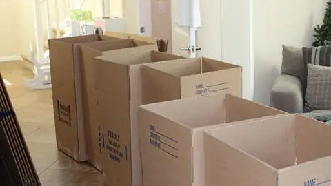 Cartons de déménagement ouverts dans un salon