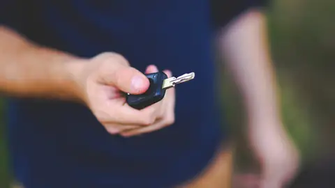 Main qui tend une clé de voiture