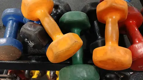 Haltères de couleur empilées dans une salle de sport